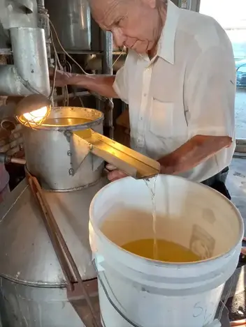 Gene Livingston drawing off mint oil from the receiving can