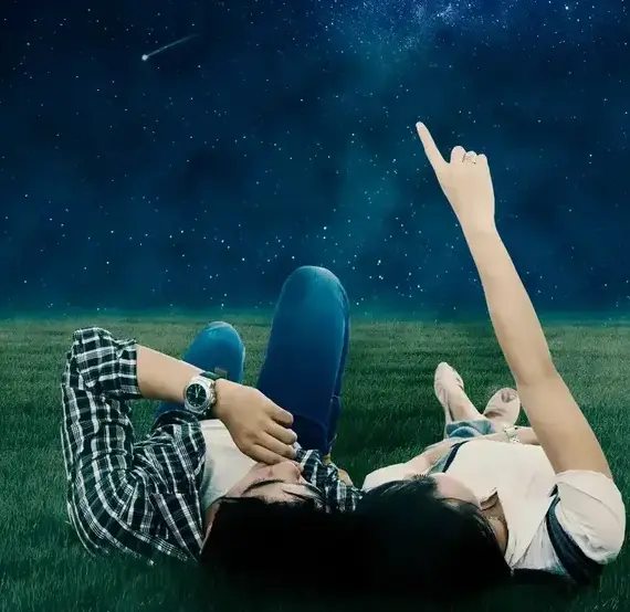 Couple laying in the grass looking at the stars
